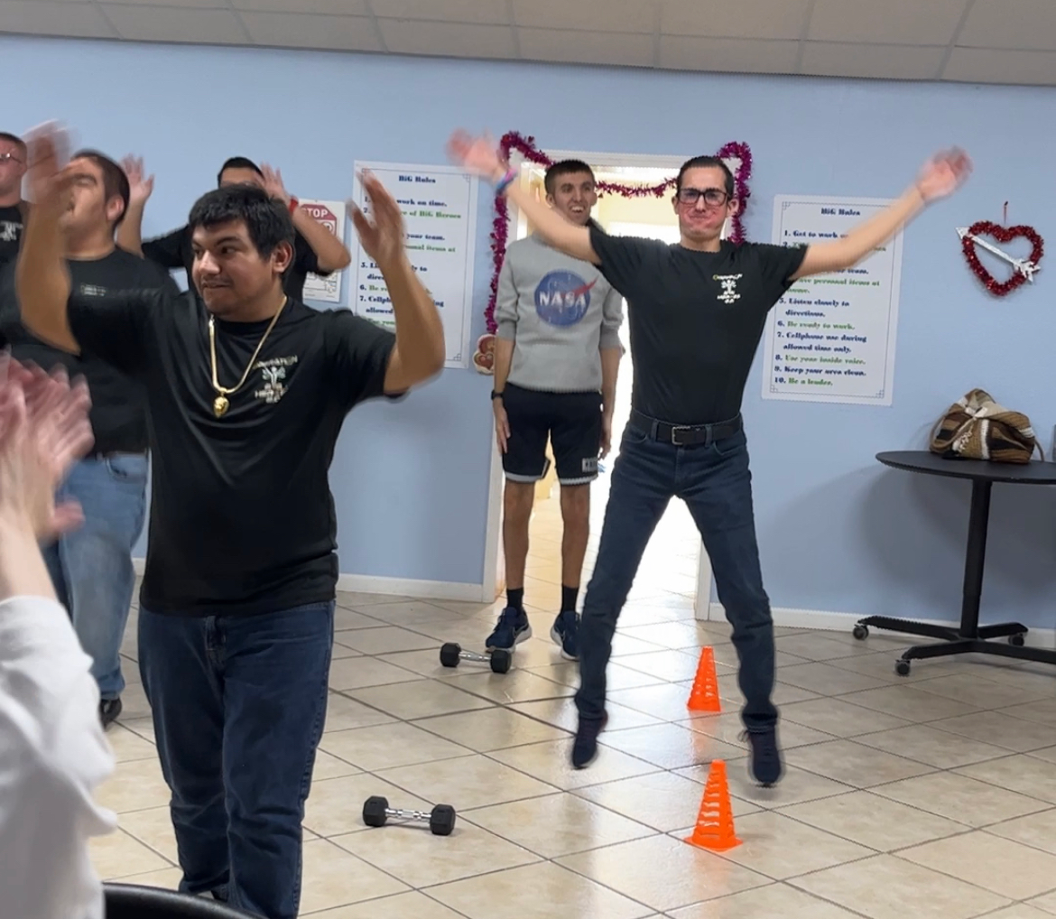 A man wearing a nasa shirt is dancing with his arms in the air