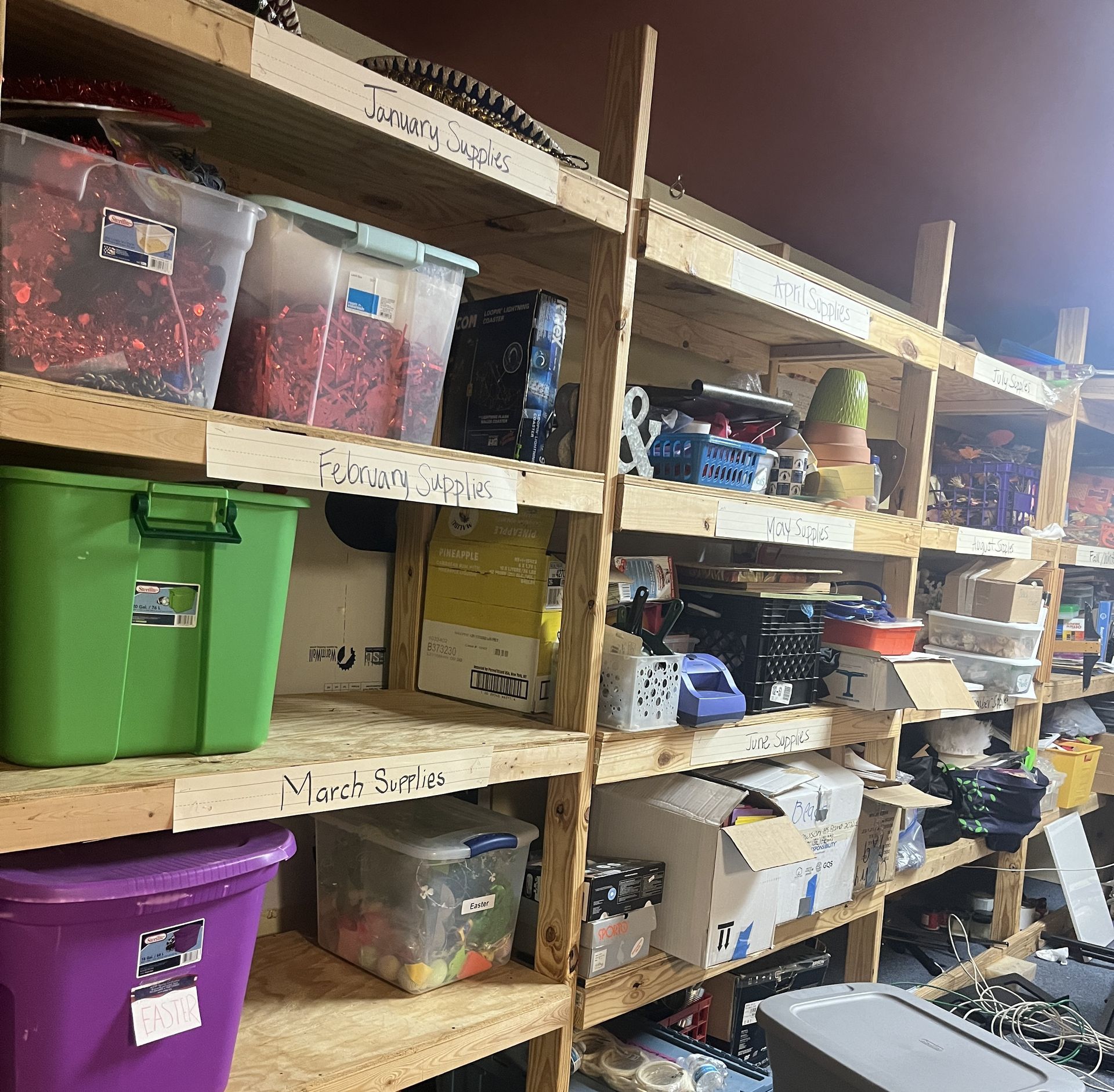 Shelves filled with storage containers and boxes labeled with handwritten names like 