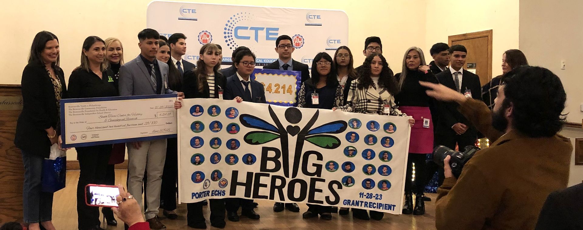 Group of students holding checks and a banner that says 