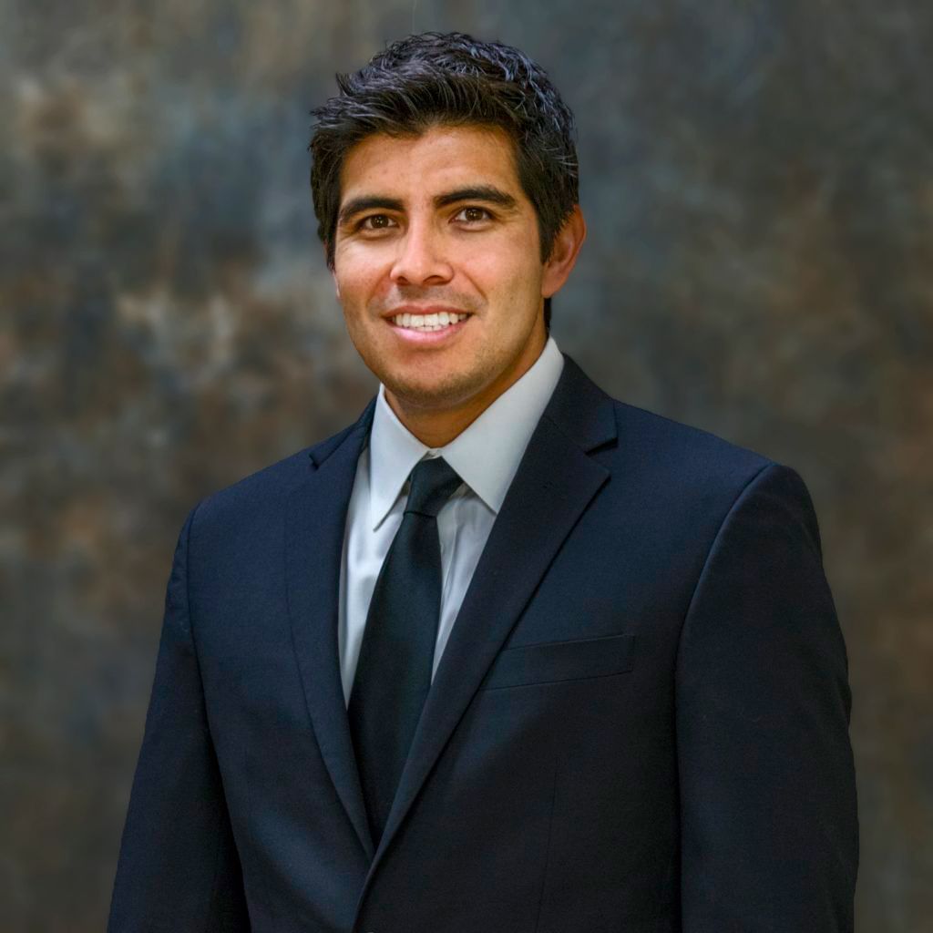 A man in a suit and tie is smiling for the camera.