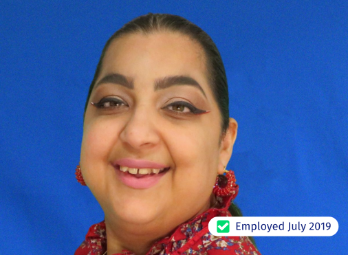 A woman is smiling in front of a blue background and has been employed since july 2019