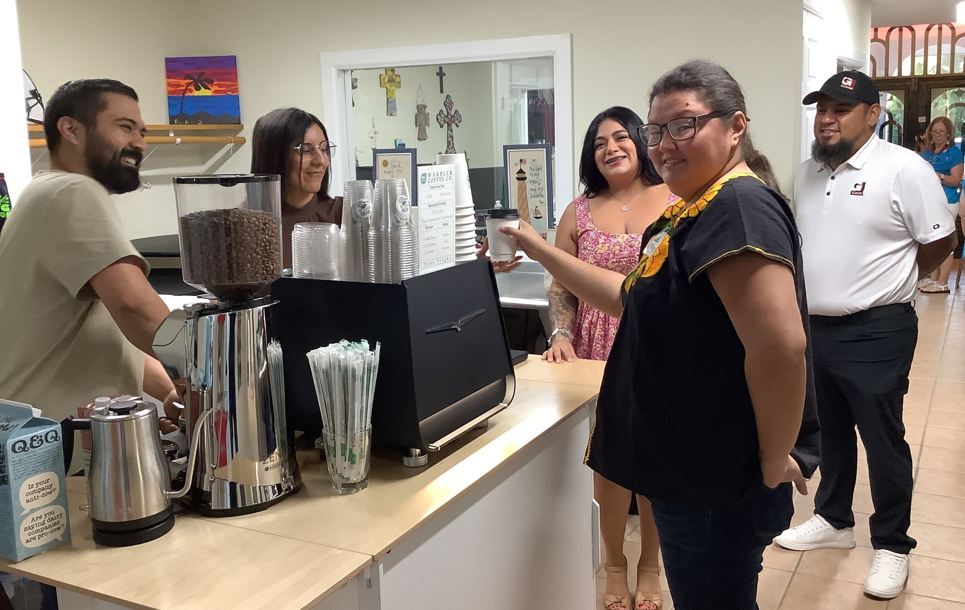 A group of people standing around a counter in a restaurant