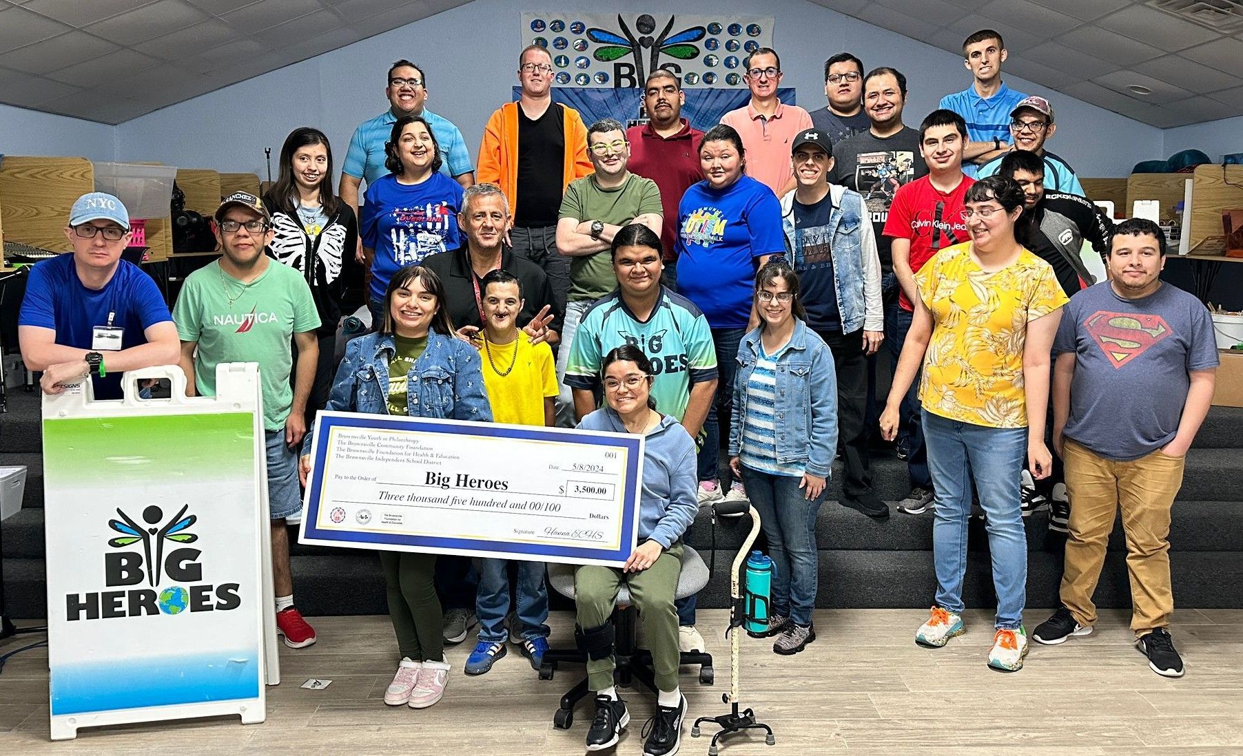 Group of people with a large check, smiling. 