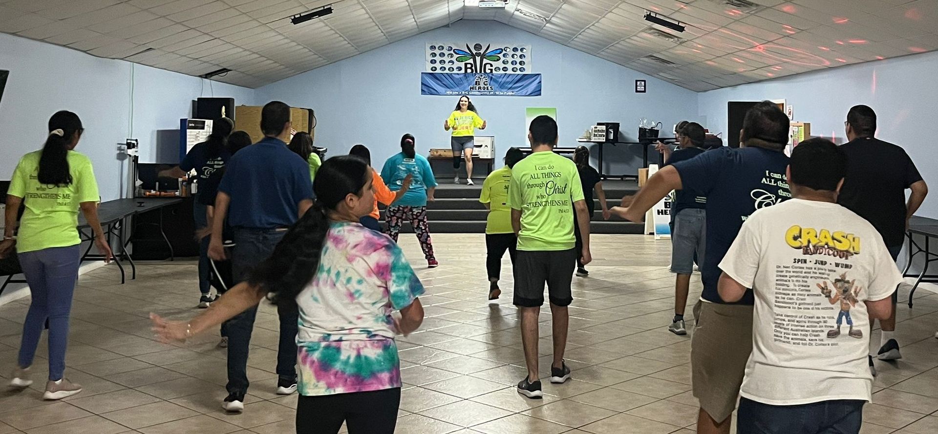 A group of people are dancing in a room with a sign that says freedom