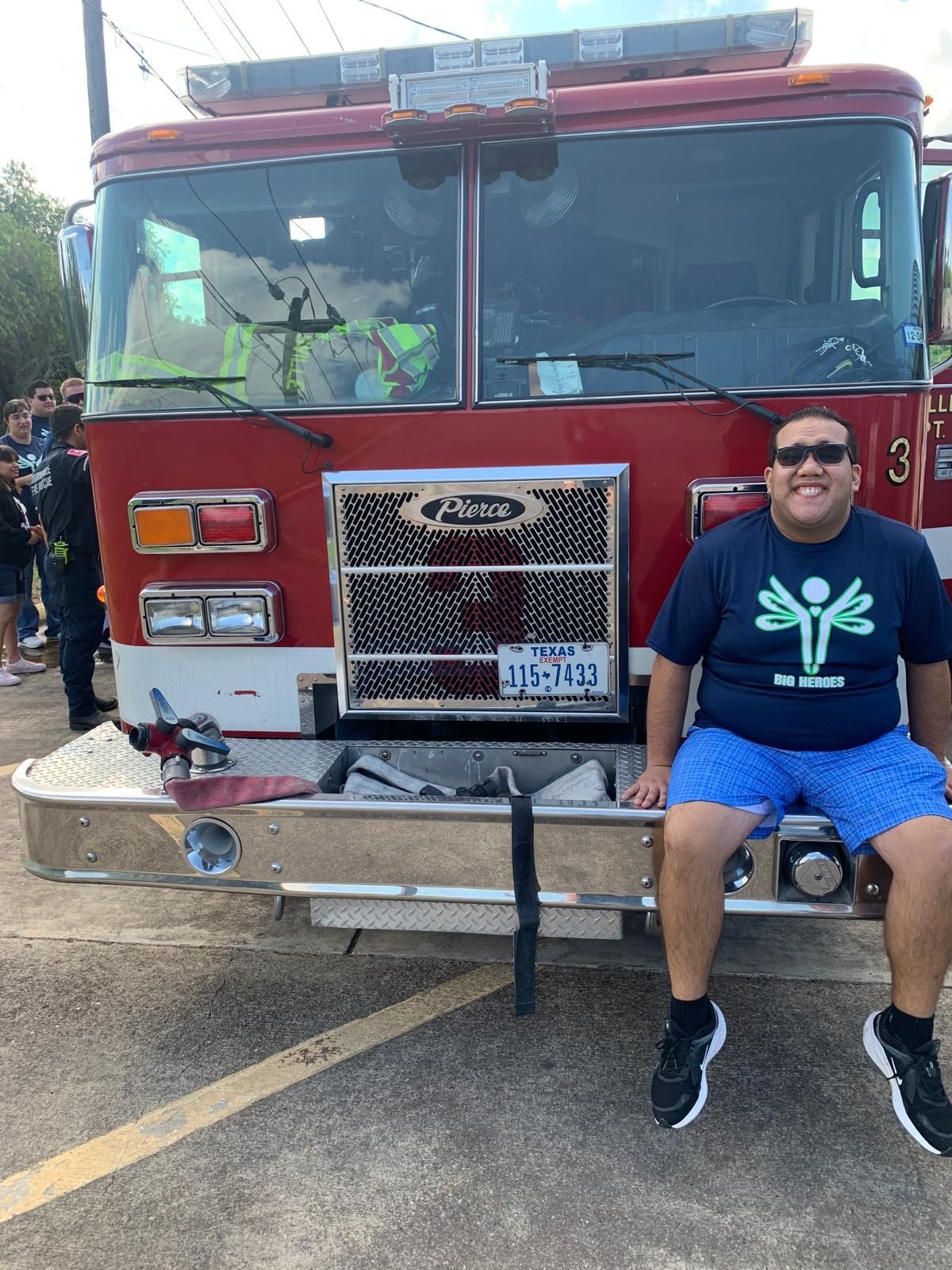 A man is sitting on the front of a fire truck.