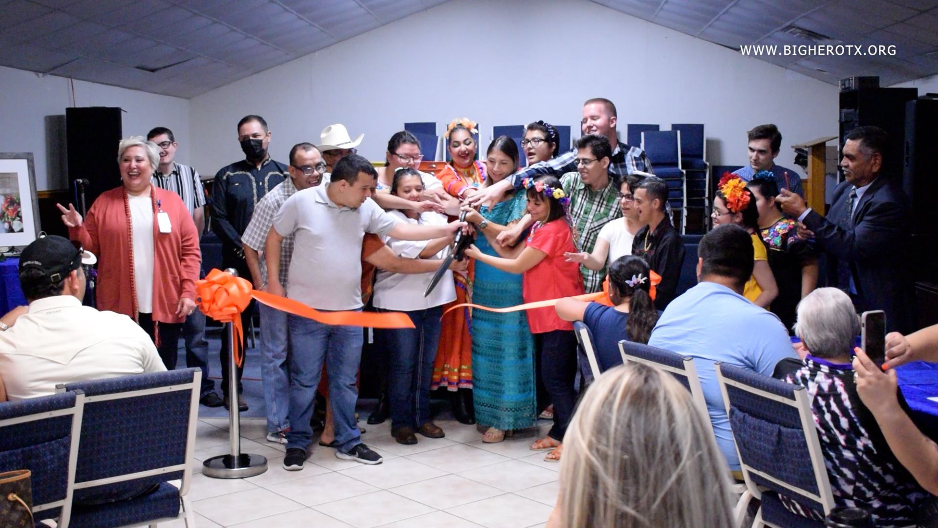 A group of people are standing around a ribbon cutting ceremony.