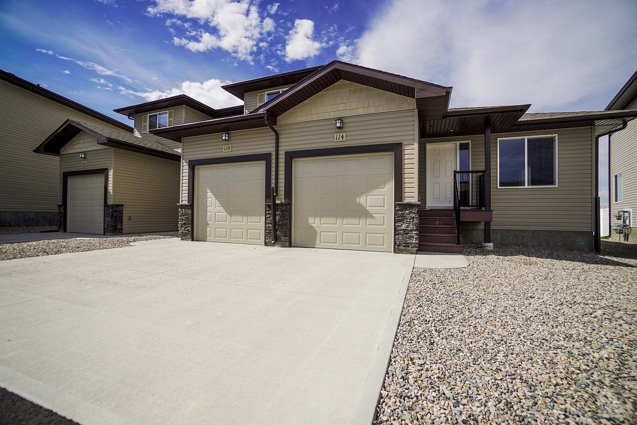concrete contractors have paved a concrete driveway in front of a residence