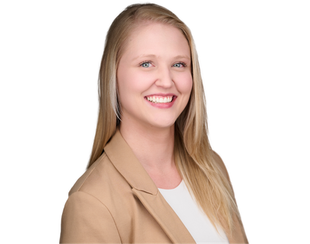 Blond woman in tan blazer smiles at the camera, against a white background.