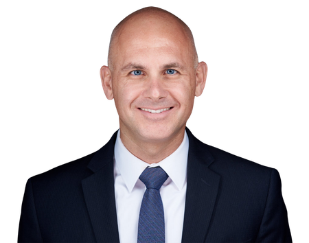 Man in suit smiling, with dark blue tie, against a white background.
