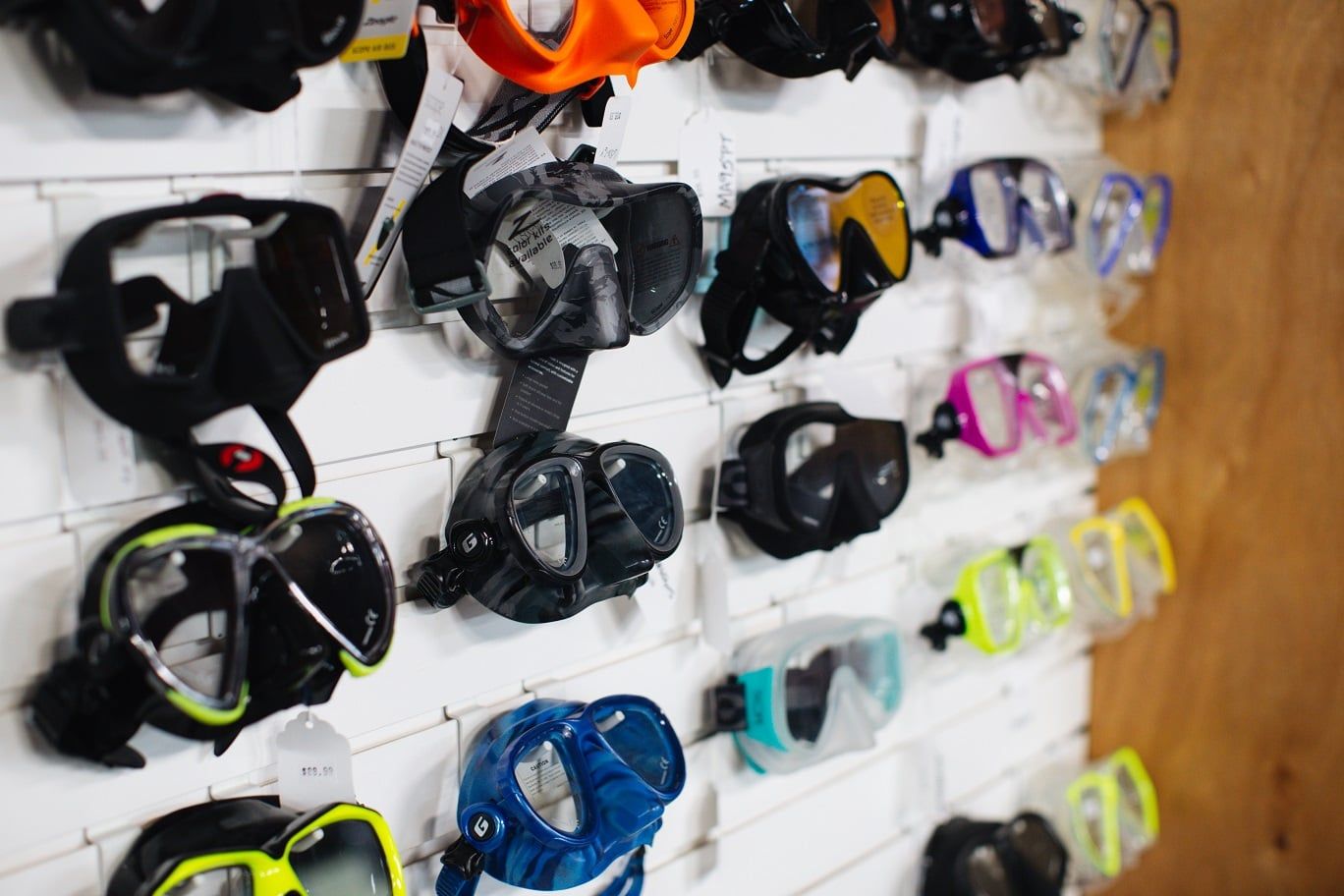 A wall filled with lots of different types of diving masks.