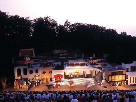 A large group of people are watching a play on a stage