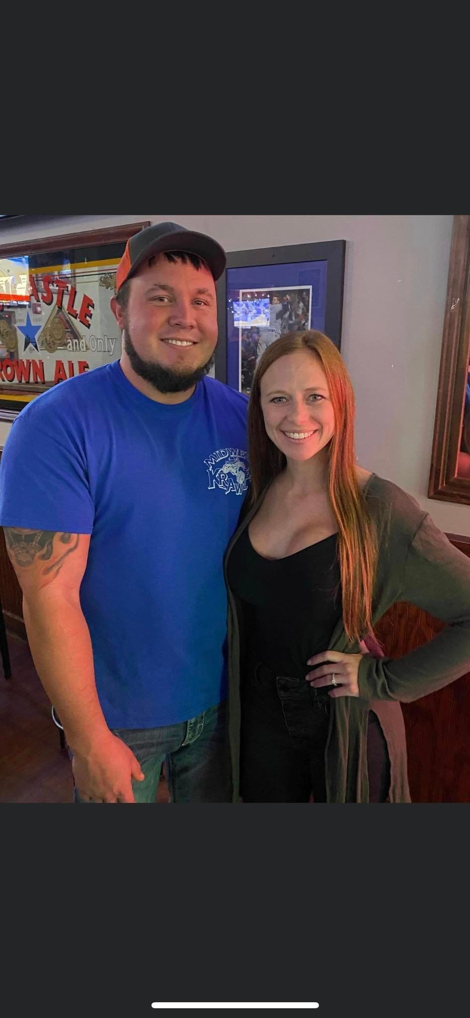 A man and a woman are posing for a picture together in a room.