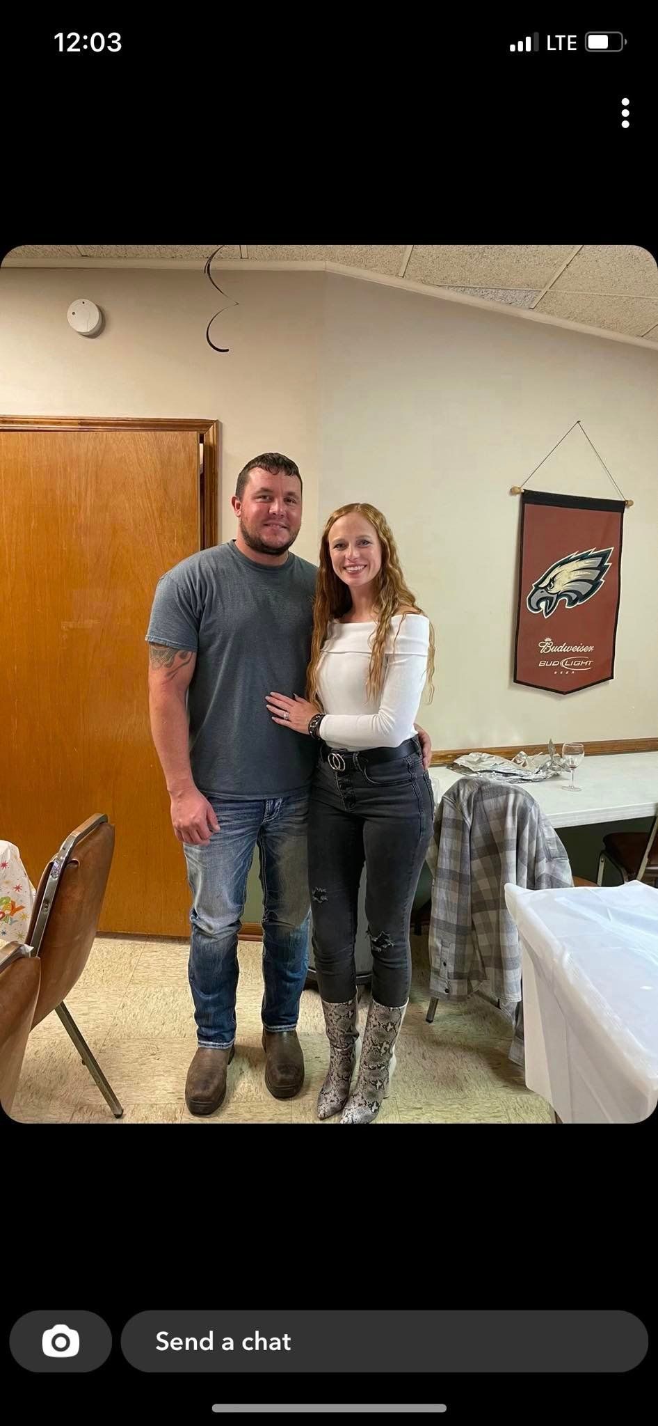 A man and a woman are posing for a picture in a room.