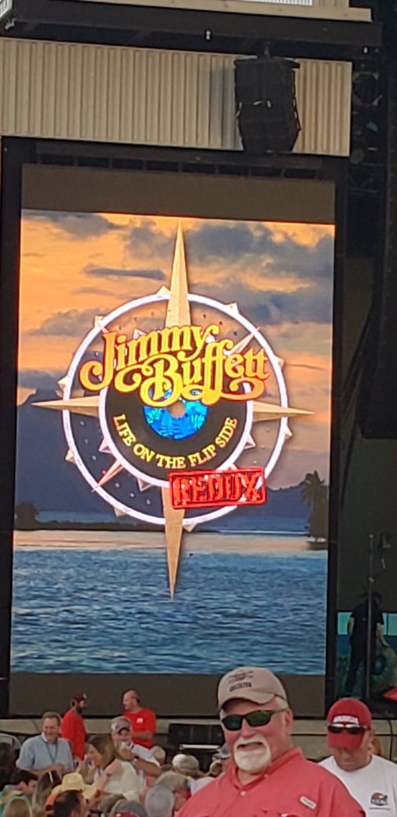 A man is standing in front of a jimmy buffet sign