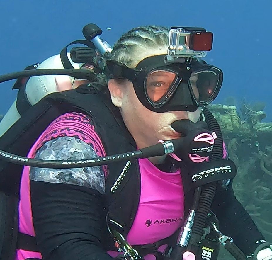 Toni in a pink shirt is scuba diving