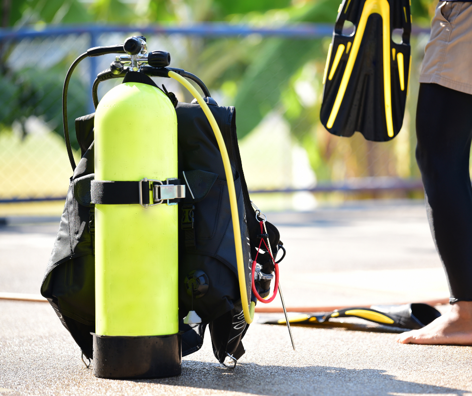 A person is standing next to a yellow scuba tank