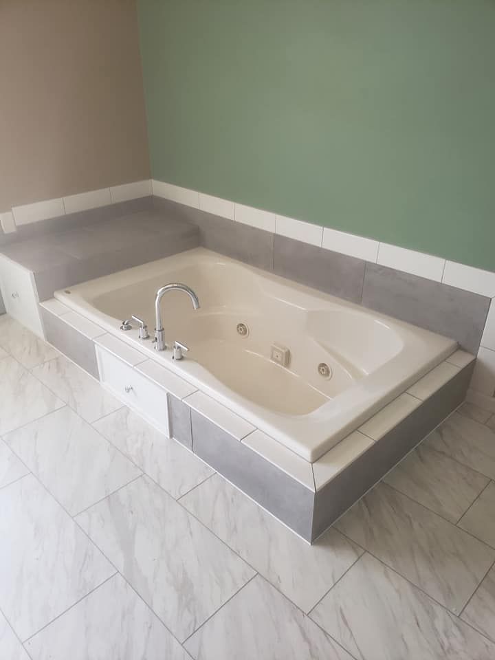 A large bathtub with a faucet in a bathroom located in Danville, IL.