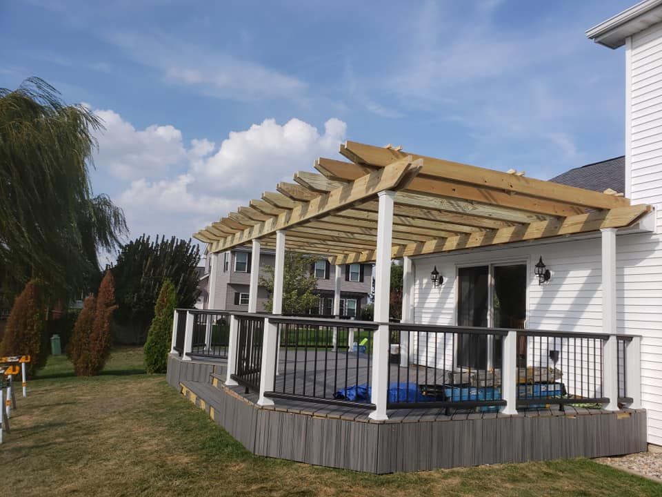 A white house with a wooden pergola over a deck located in Urbana, IL.