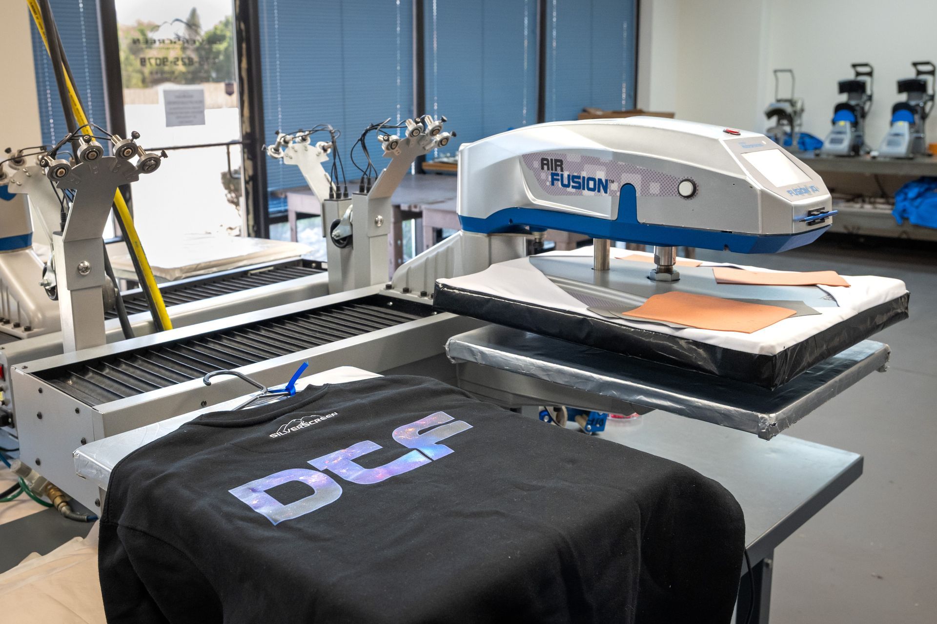 DTF heat press with a black t-shirt that reads DTF