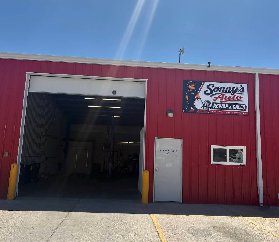Red auto repair shop with open garage bay and Sonny’s Auto sign on the front wall| Sonny's Automotive Repair and Sales