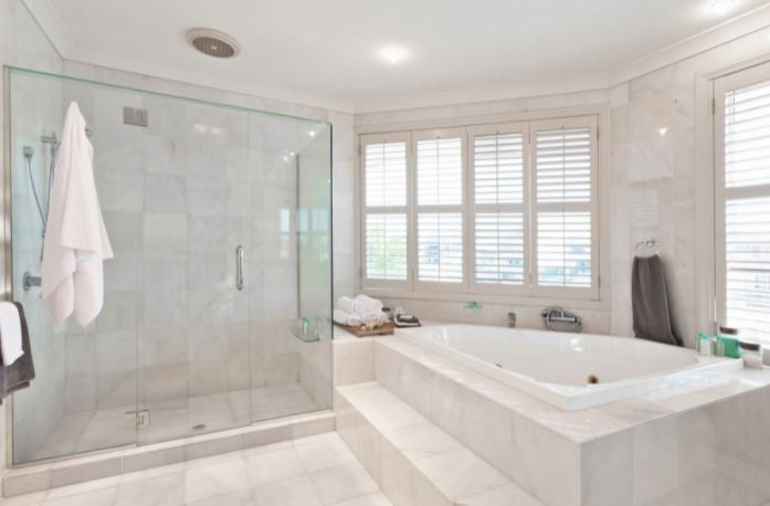 This is a photo of wall tiles being fitted to a wall with grey grout behind it