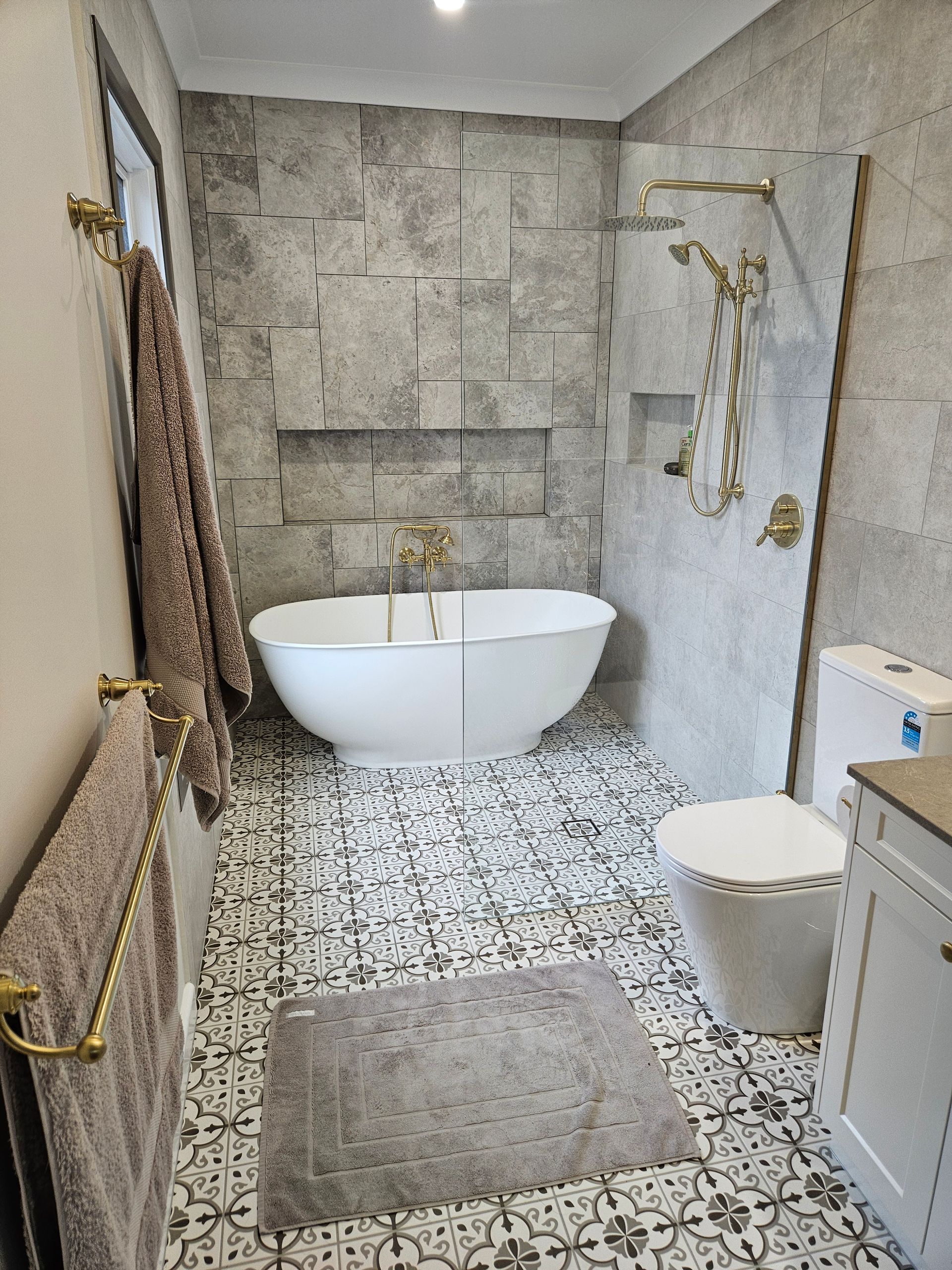 A bathroom with a tub , toilet , and shower.