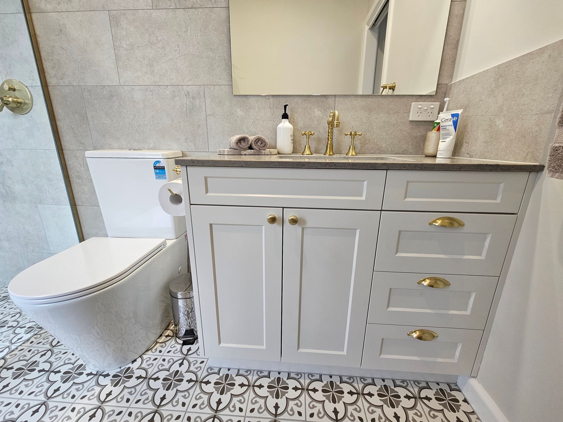 A bathroom with a toilet , sink and mirror