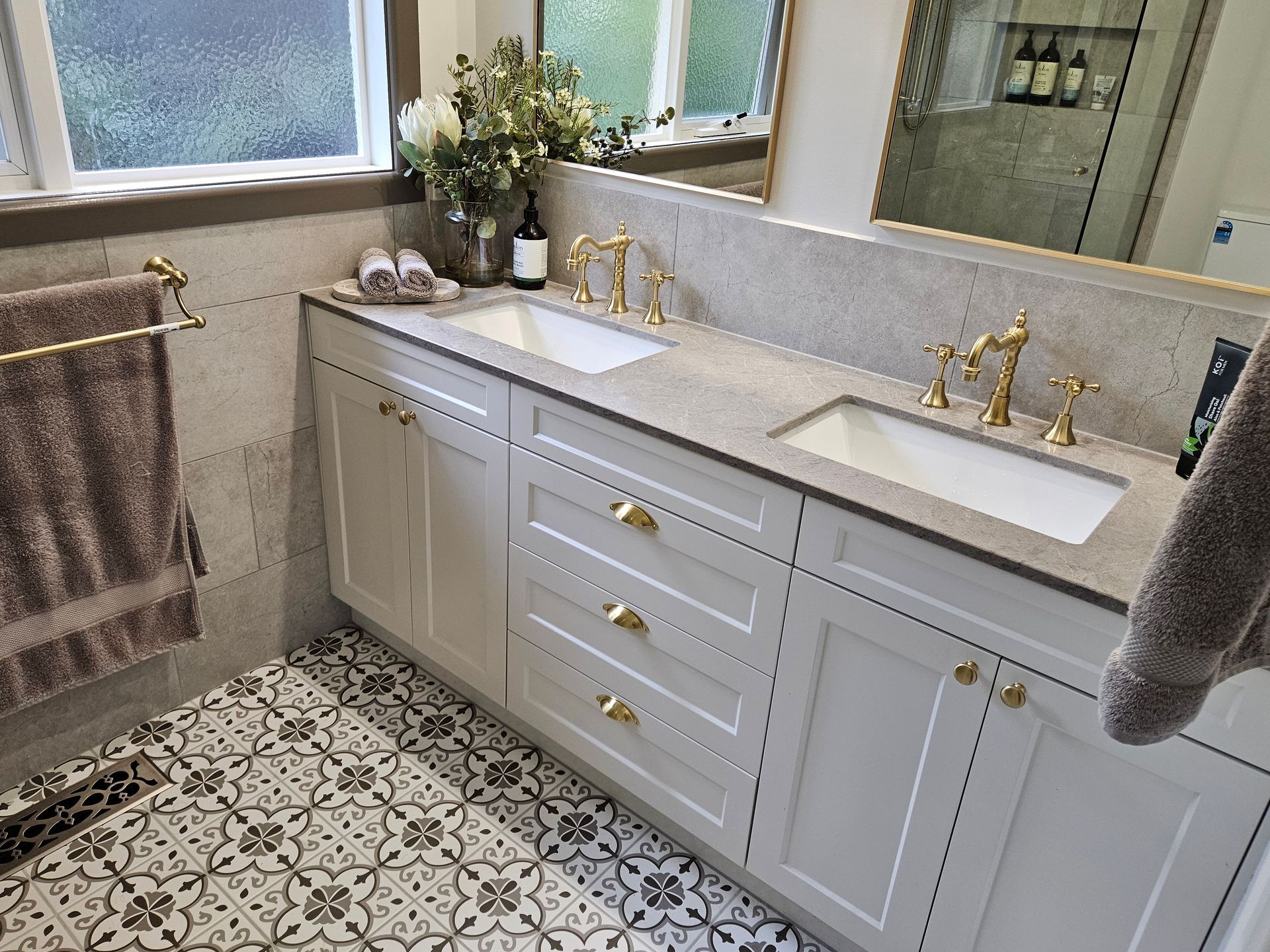 A bathroom with two sinks and a mirror.