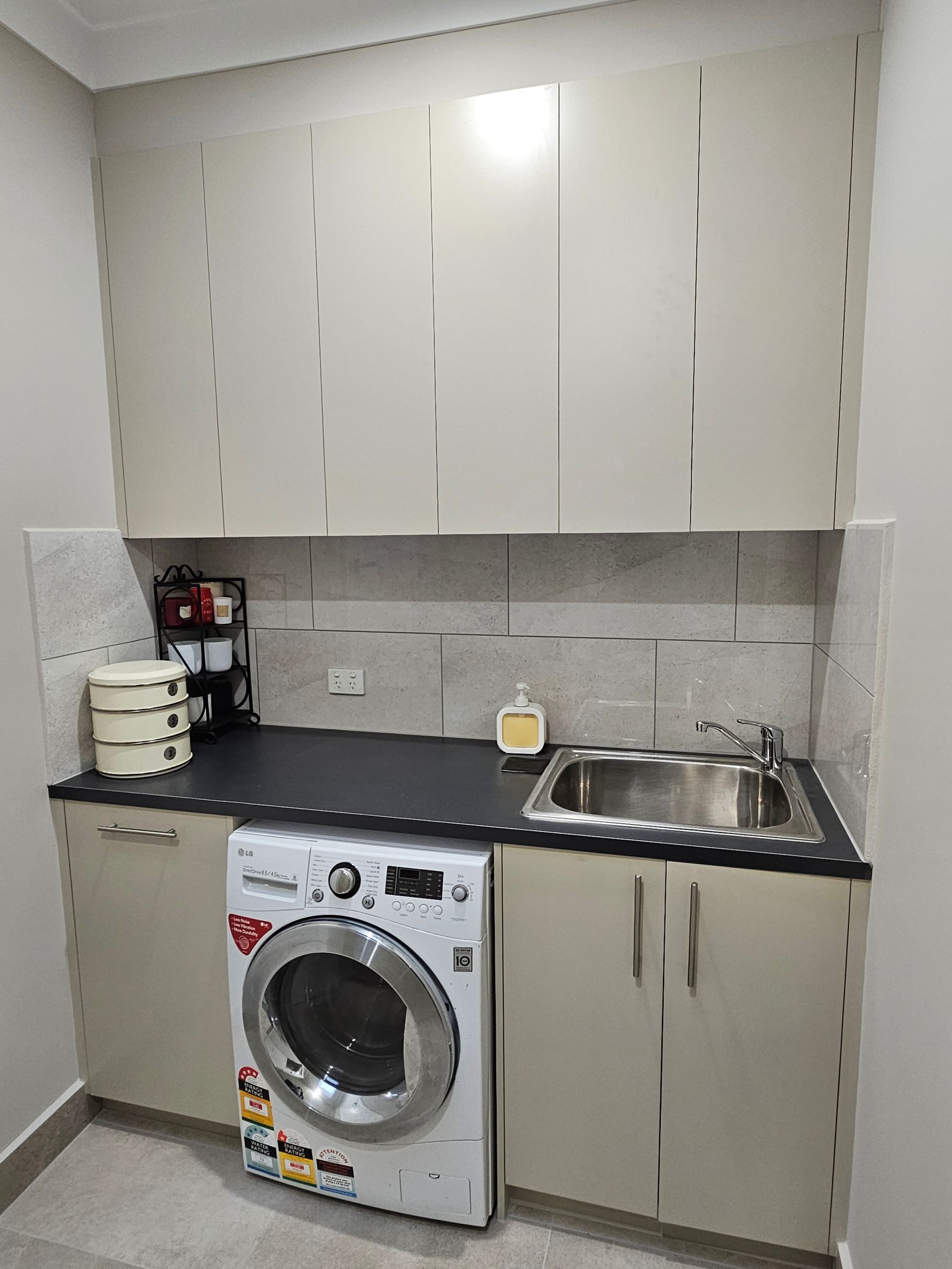 A laundry room with a washer and dryer and a sink.
