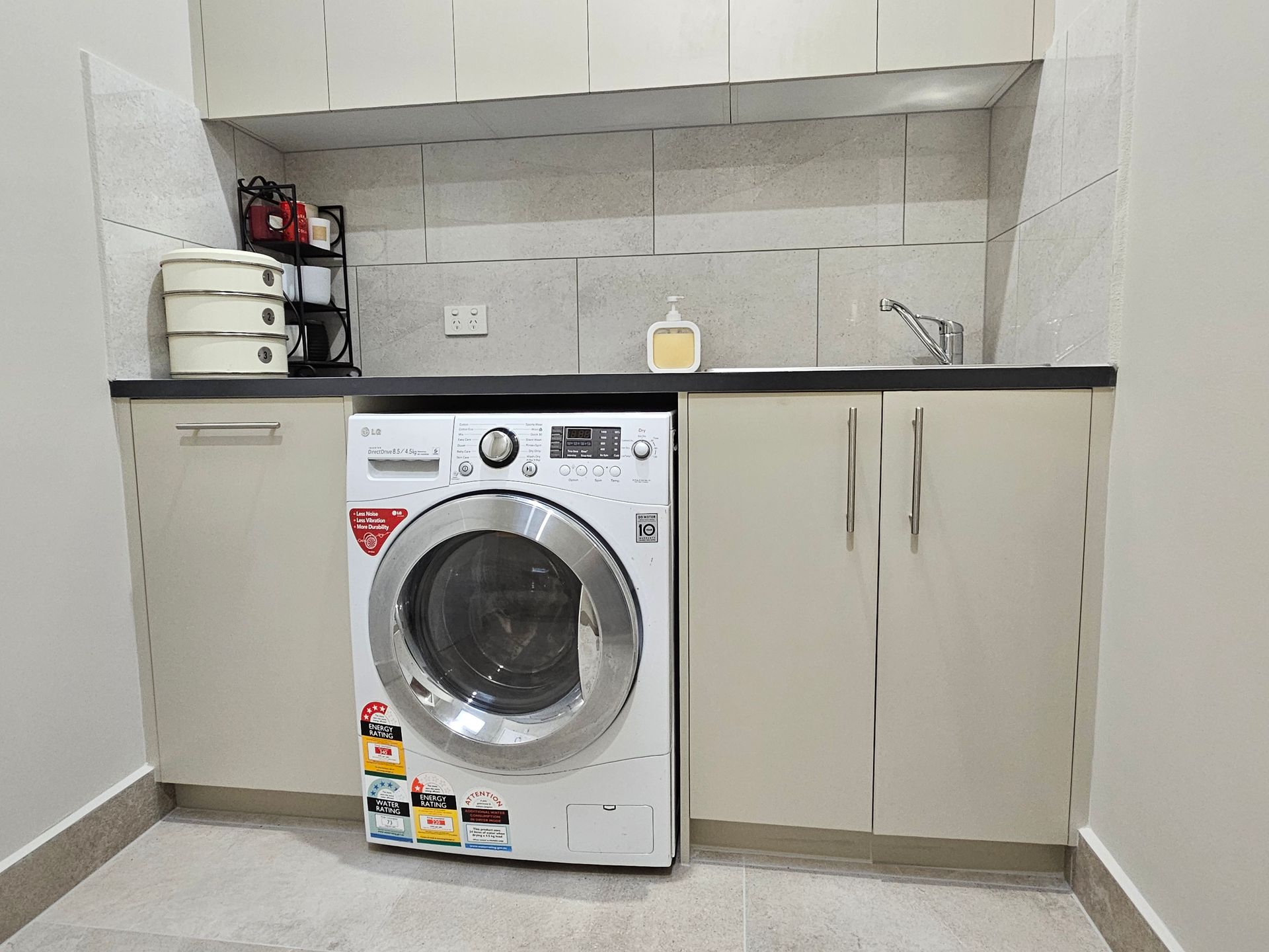 A laundry room with a washing machine and a sink.