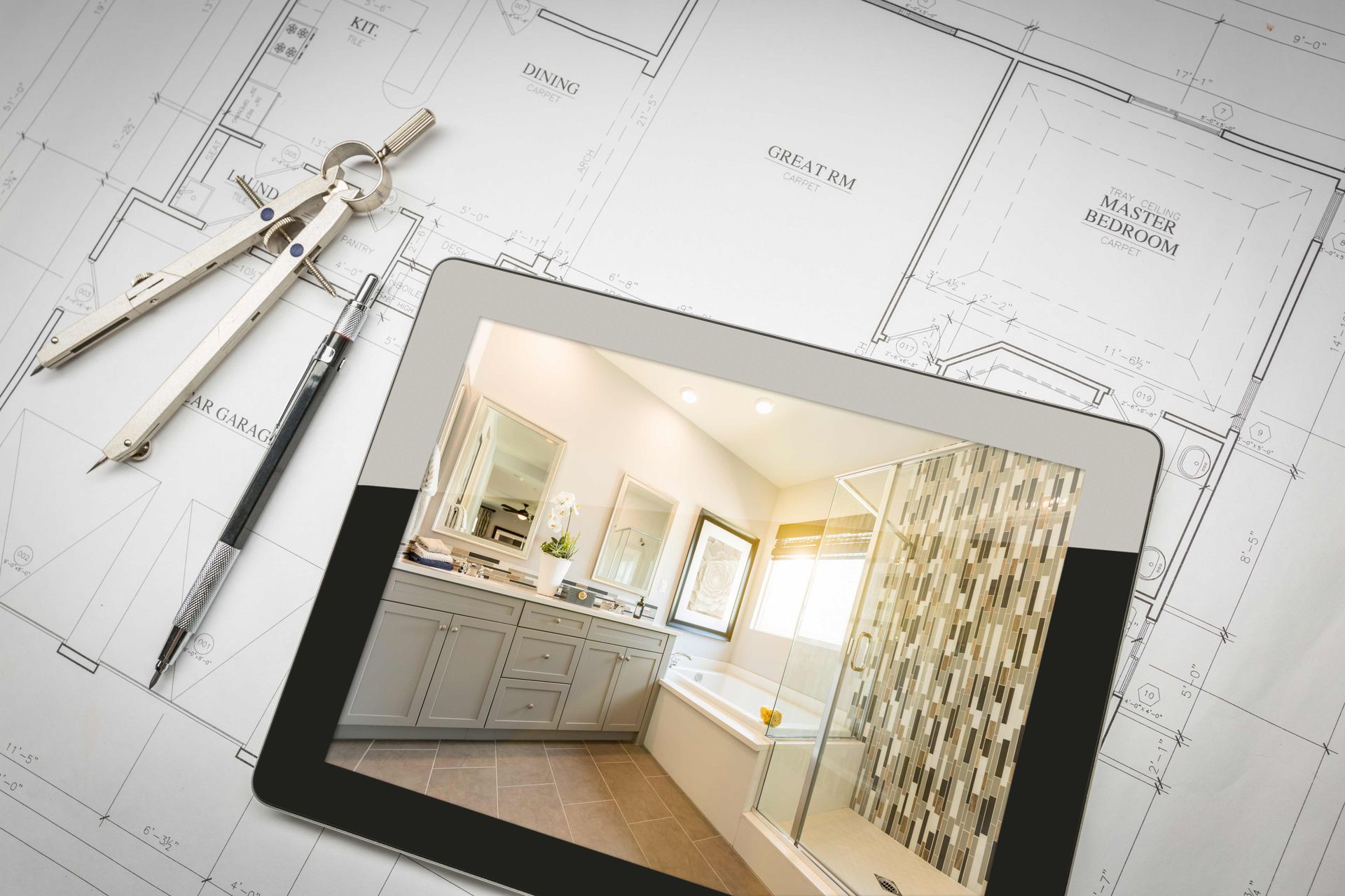A tablet with a bathroom design on top of house blueprints.