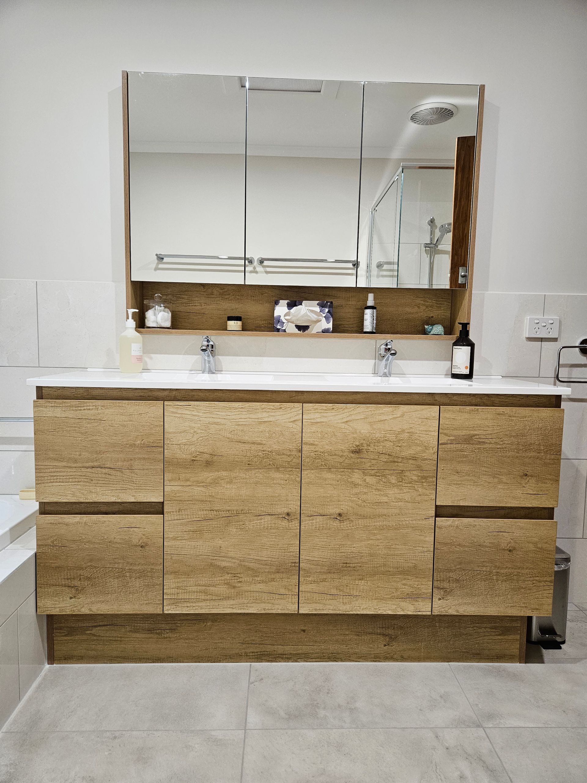 A bathroom with two sinks , a mirror and a bathtub.