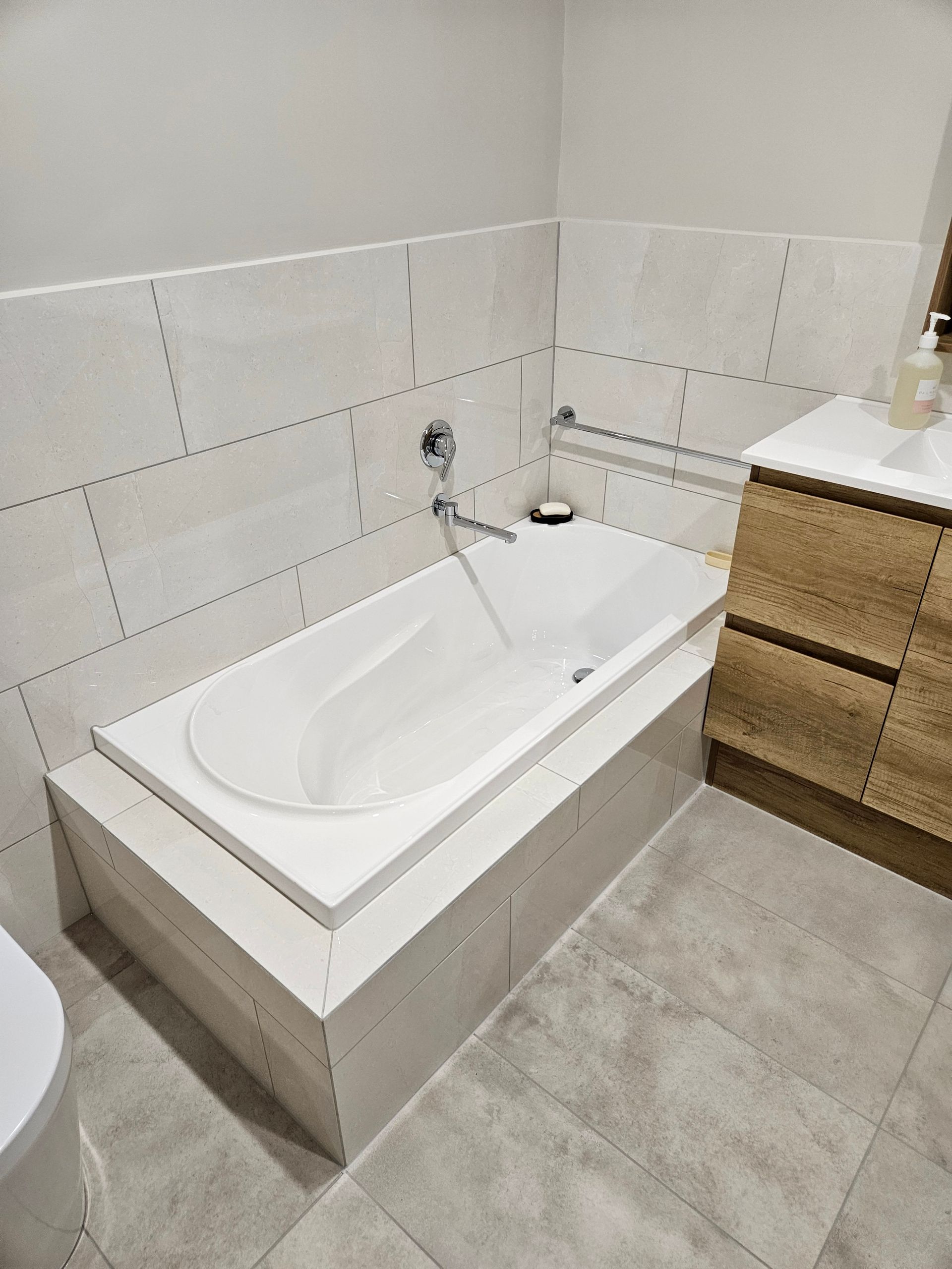 A bathroom with a bathtub , sink , toilet and vanity.