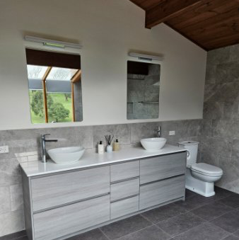 A bathroom with two sinks and a toilet
