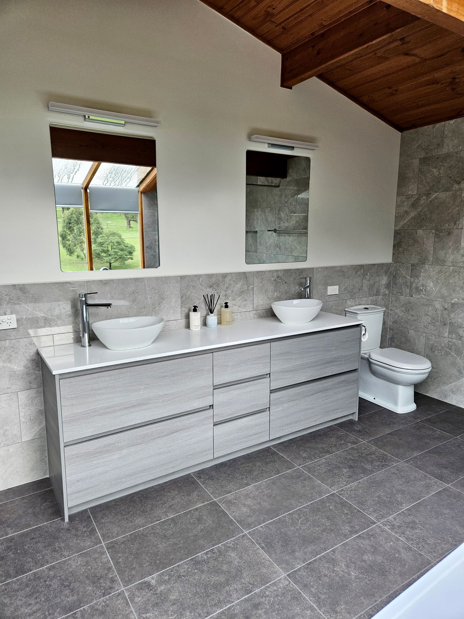 A bathroom with two sinks and a toilet