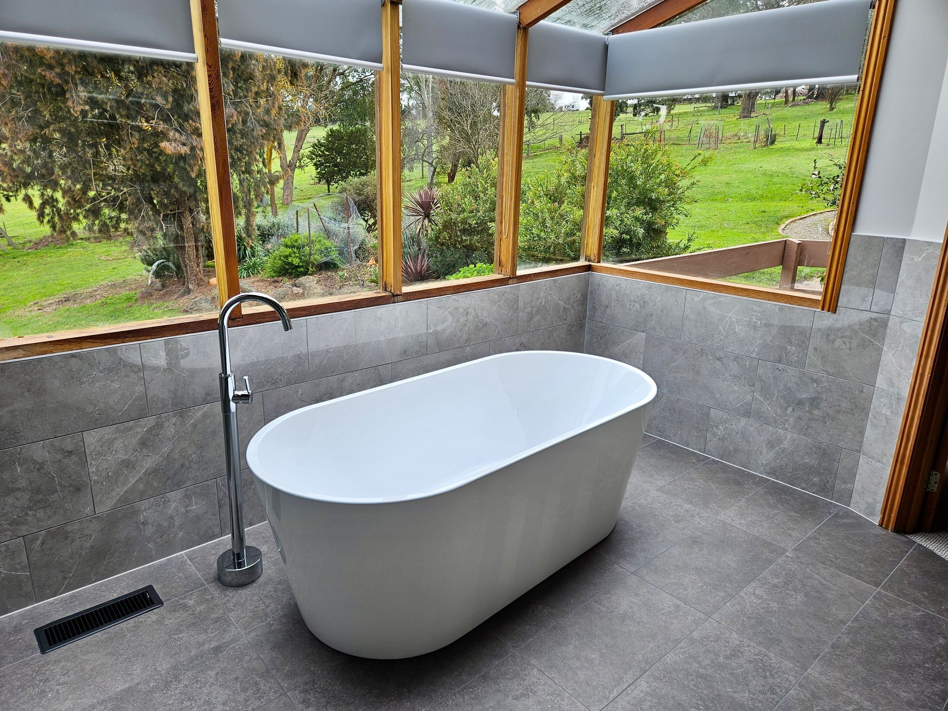 A bathroom with a bathtub and a large window