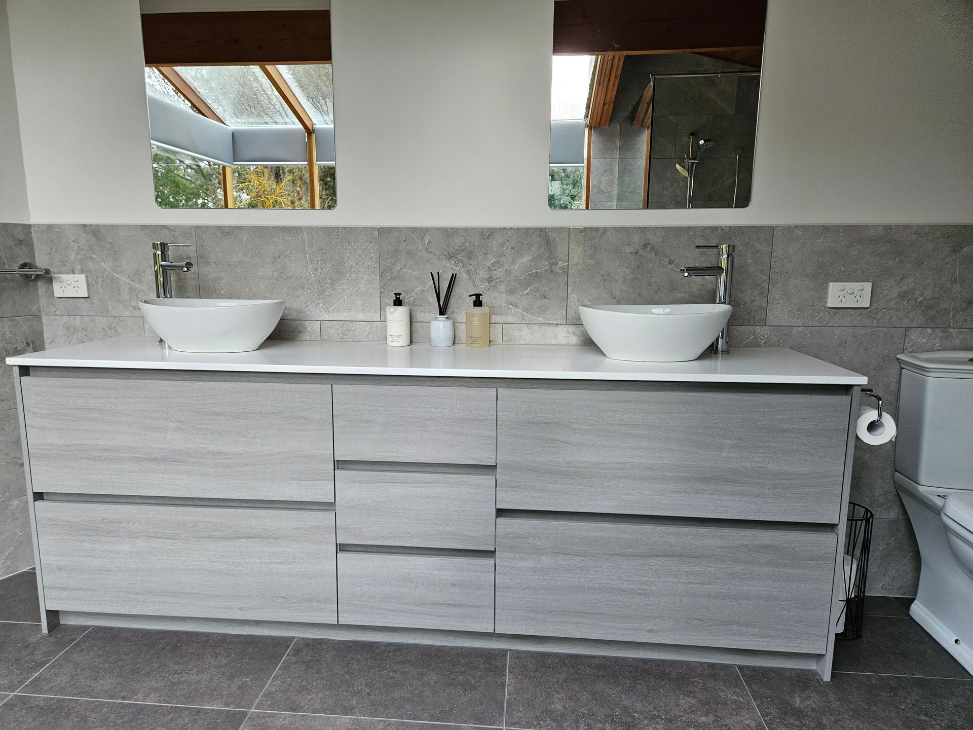 A bathroom with two sinks and a toilet.
