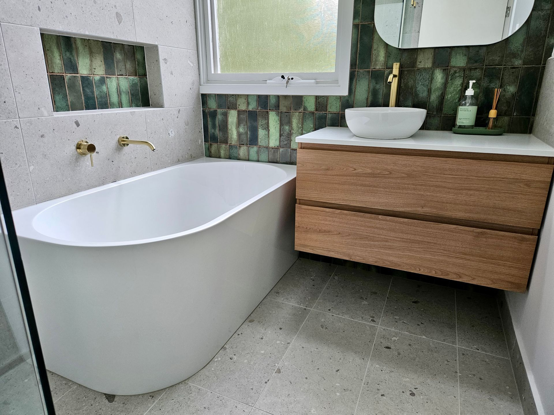 A bathroom with a bathtub , sink and mirror.