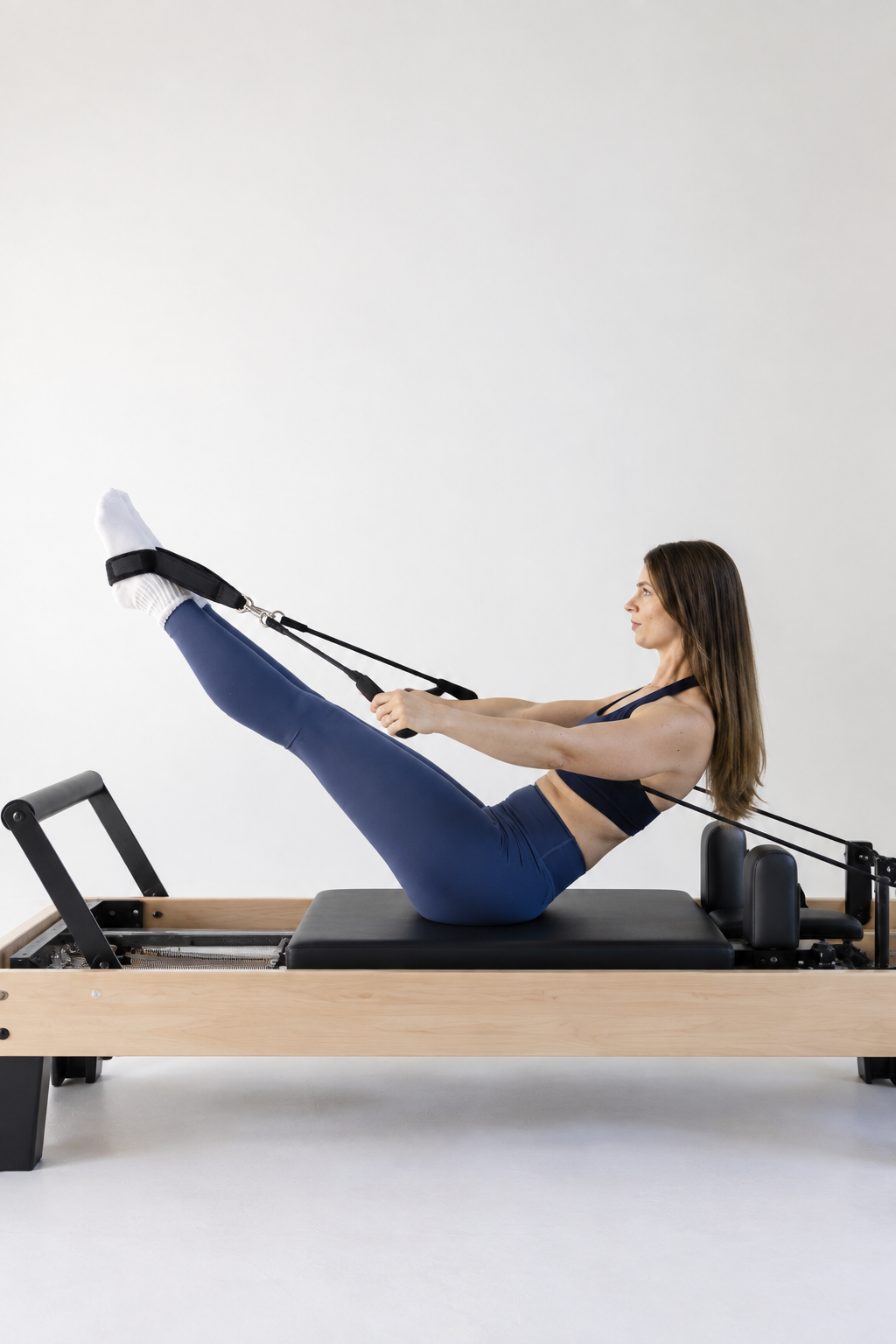 A woman does pilates on a pilates reformer