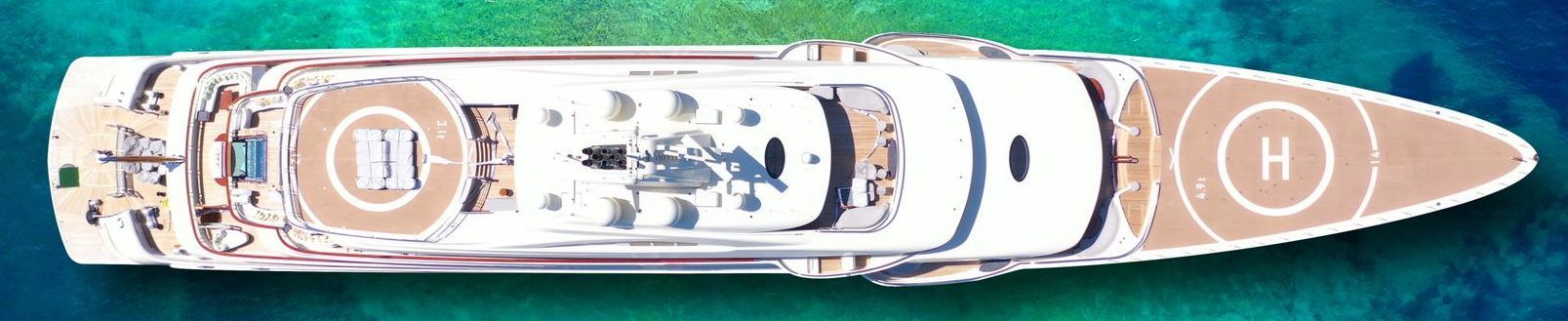 large white superyacht moored in tropical sea