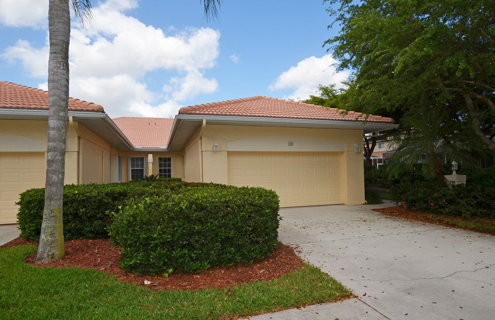 Single-story suburban house with a two-car garage, driveway, and landscaped front yard