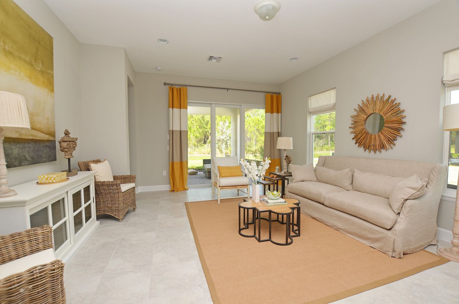 Bright living room with beige sofa, tan rug, white fireplace, and sliding glass doors to a patio.