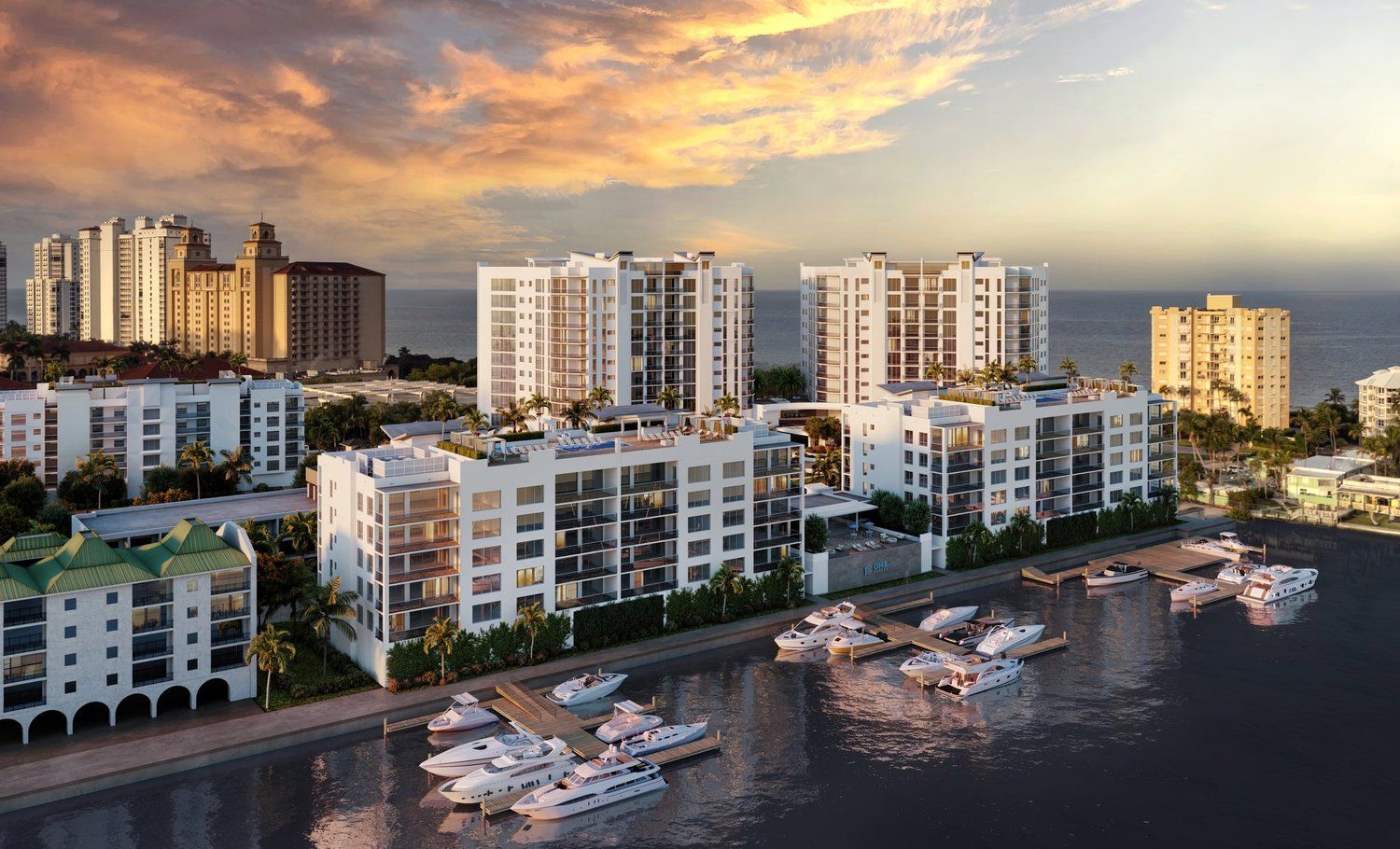 Waterfront apartment buildings at sunset with boats docked along the marina