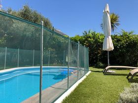 A Swimming Pool With A Glass Fence Around It | Cranbourne, VIC | Cranbourne Fencing Pty Ltd