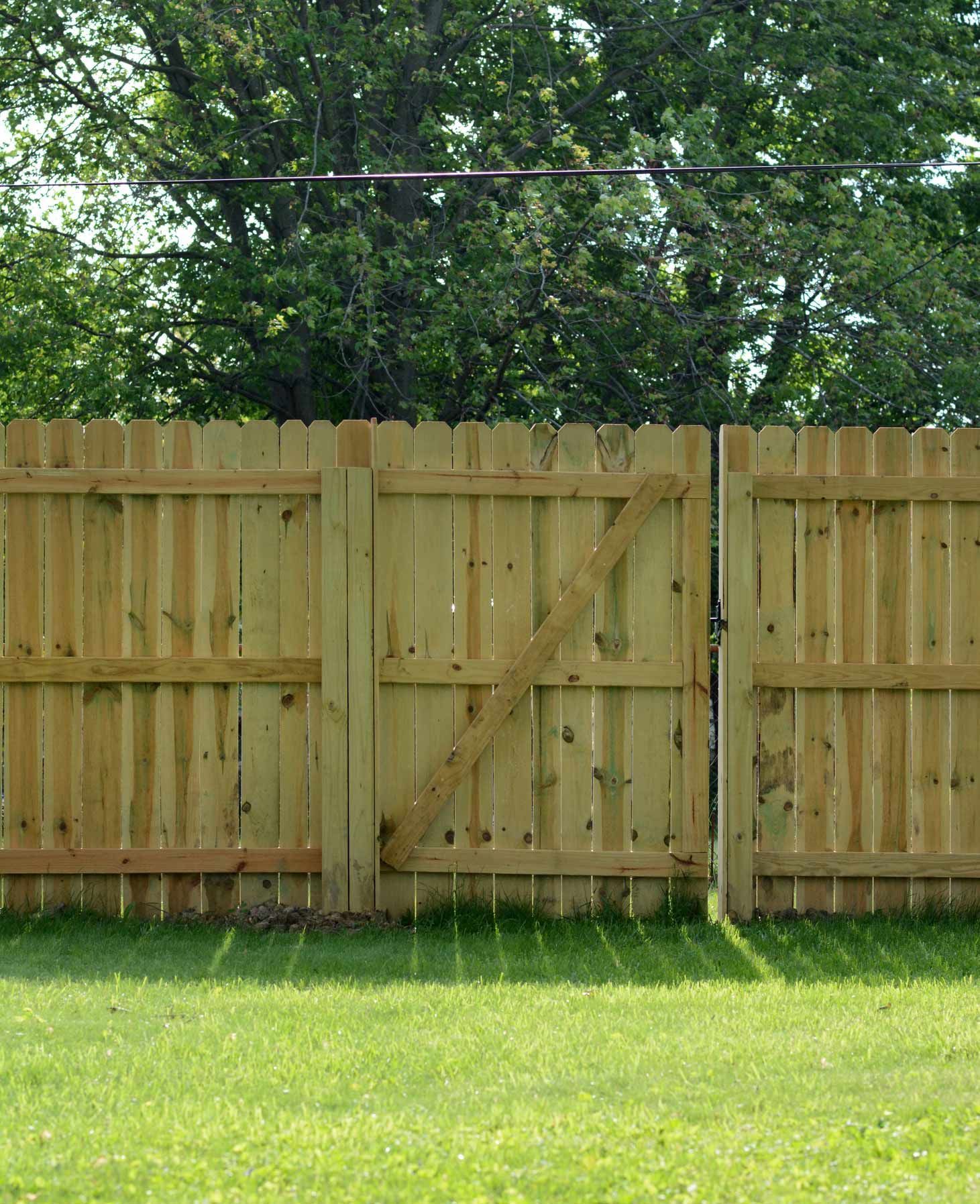 A Wooden Fence with A Gate in The Middle of A Lush Green Field | Cranbourne, VIC | Cranbourne Fencing Pty Ltd