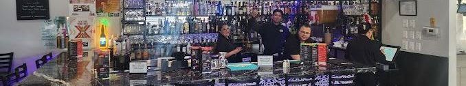 A blurry picture of a bar with people standing behind it.