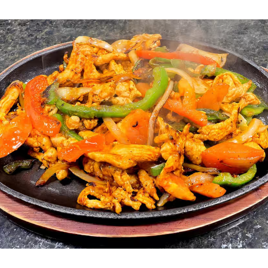 A close up of a plate of food with chicken and vegetables on a table.
