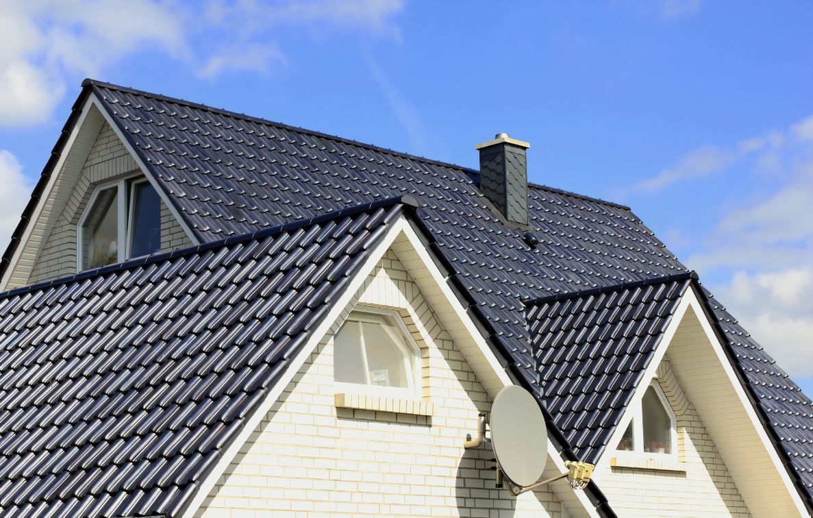 A White House With a Black Roof and a Satellite Dish — Stormguard Roofing In Caloundra West, QLD