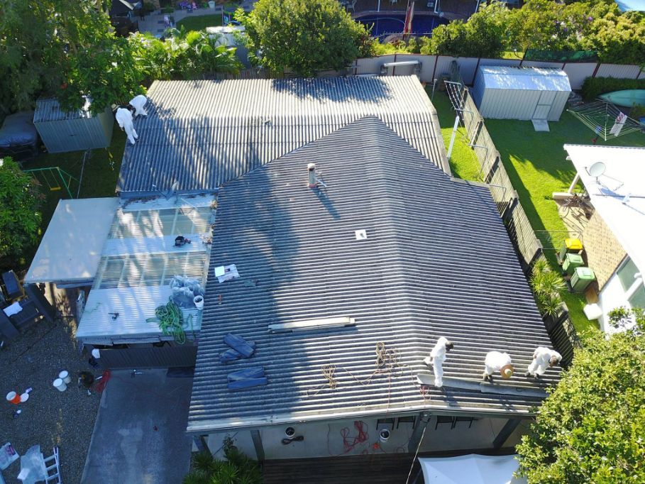 An Aerial View of a House With a Roof Being Repaired — Stormguard Roofing In Caloundra West, QLD