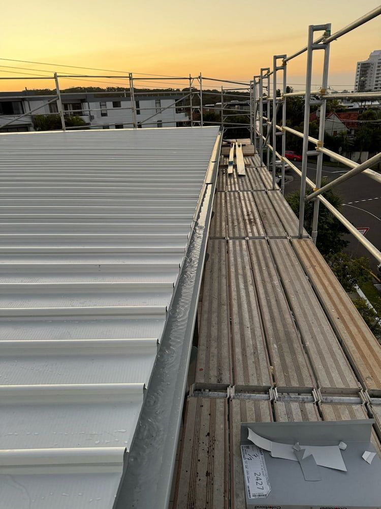 A Wooden Scaffolding is Sitting on Top of a Metal Roof — Stormguard Roofing In Caloundra, QLD